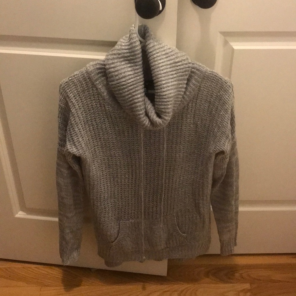 Gray turtleneck sweater with pocket.
